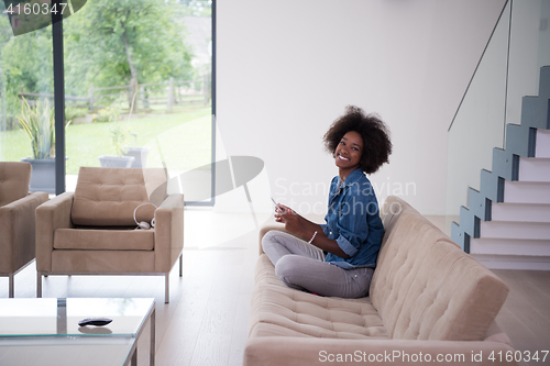 Image of african american woman at home with digital tablet