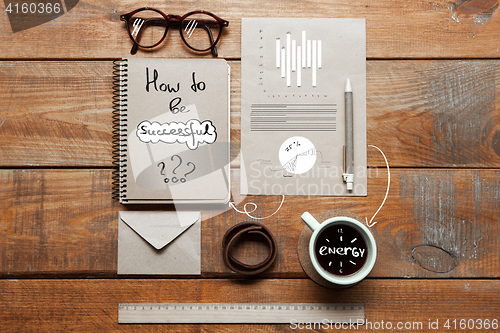 Image of Notebook, coffee cup, glasses and pen on table. Business concept.