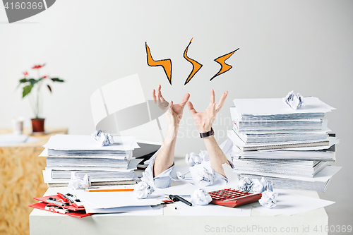 Image of The many crumpled papers on desk of stressed male workplace