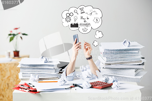 Image of The many crumpled papers on desk of stressed male workplace