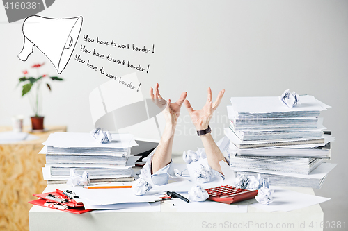 Image of The many crumpled papers on desk of stressed male workplace