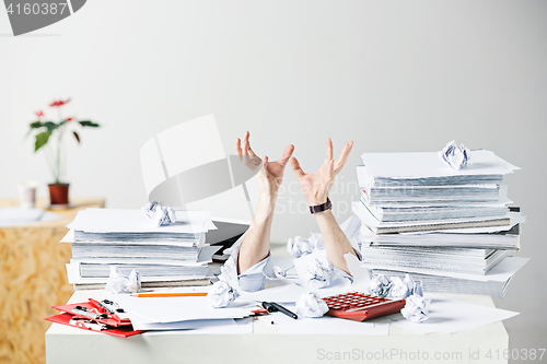 Image of The many crumpled papers on desk of stressed male workplace