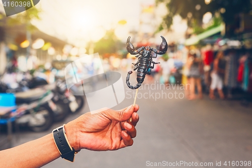 Image of Thai vendor showing roasted scorpio