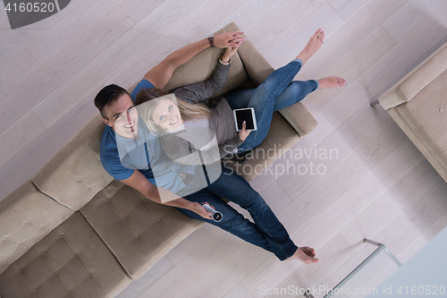 Image of youg couple in living room with tablet top view