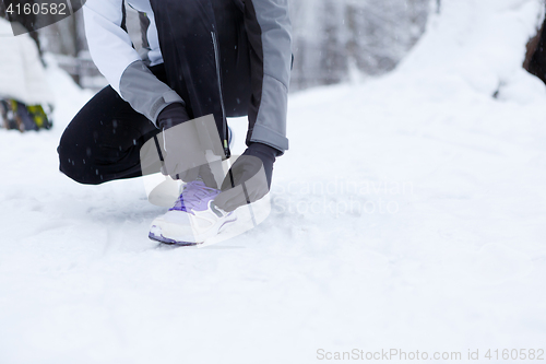 Image of Girl corrects shoes in winter