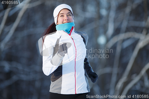 Image of Woman running in winter park