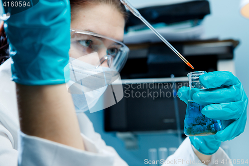 Image of Woman with protective glasses , flask