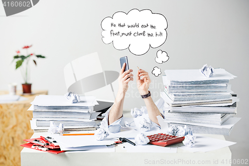 Image of The many crumpled papers on desk of stressed male workplace