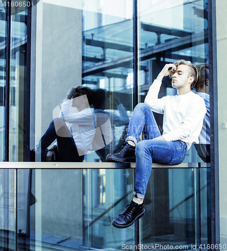Image of young modern hipster guy at new building university blond fashion hairstyle having fun, lifestyle people concept 