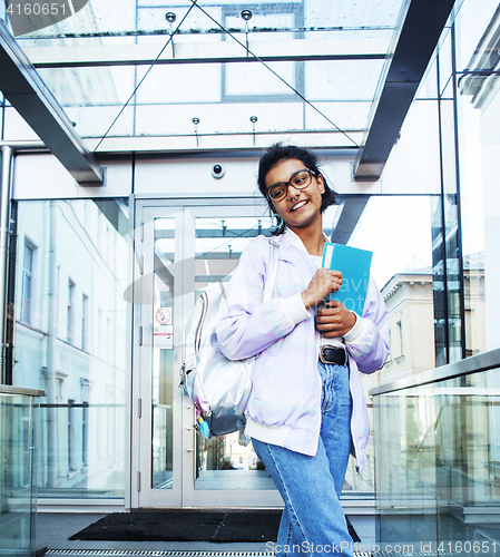 Image of young cute modern indian girl at university building sitting on 