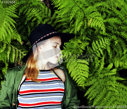 Image of Pretty young blond girl hipster in hat among fern, vacation in g