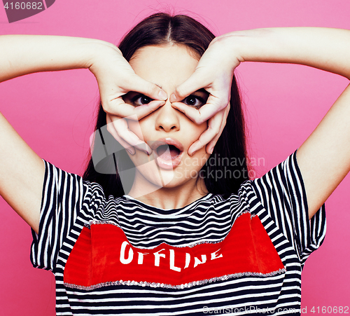 Image of young pretty teenage woman emotional posing on pink background, fashion lifestyle people concept 