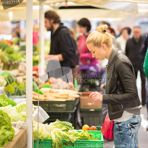 Image of Woman buying vegetable at local food market. 