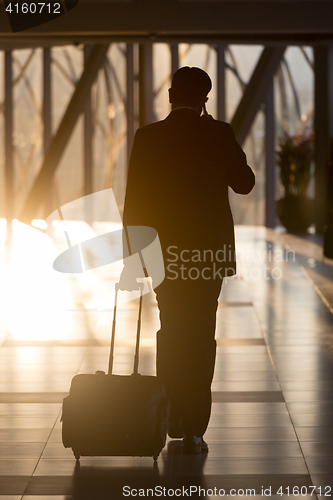 Image of Businessman at airport corridor walking to departure gates.