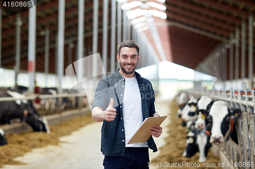 Image of farmer with cows showing thumbs up on dairy farm