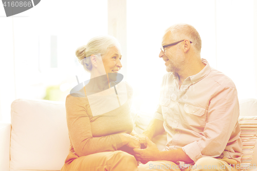 Image of happy senior couple hugging on sofa at home