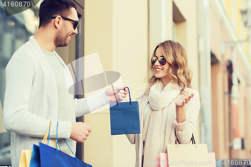 Image of happy couple with shopping bags in city