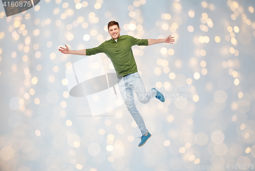 Image of smiling young man jumping in air