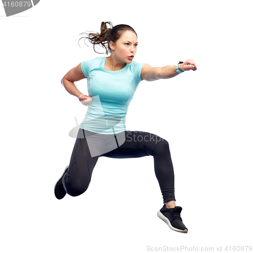 Image of happy sporty young woman jumping in fighting pose