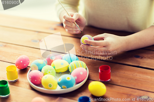 Image of close up of woman hands coloring easter eggs