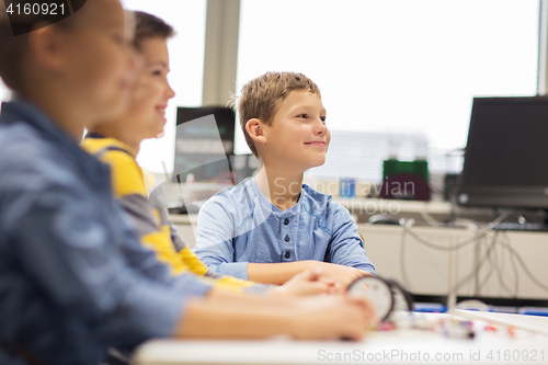 Image of happy children building robots at robotics school