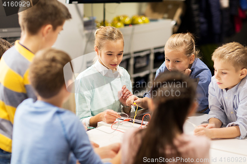 Image of happy children building robots at robotics school