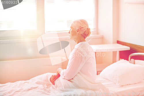 Image of senior woman patient lying in bed at hospital ward