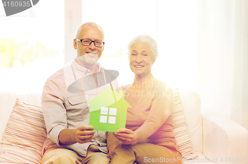 Image of happy senior couple hugging on sofa at home