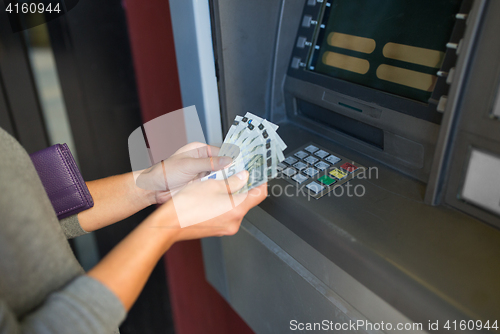 Image of close up of hand withdrawing money at atm machine