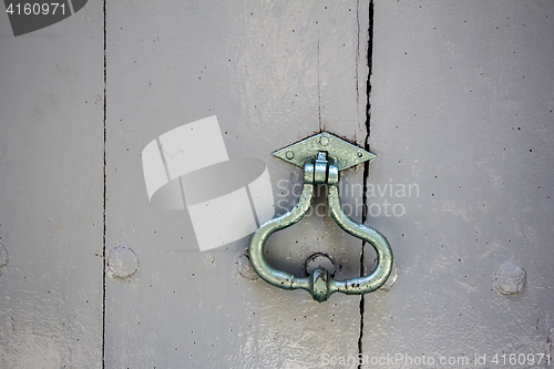 Image of Old door knocker on an old wooden entrance door