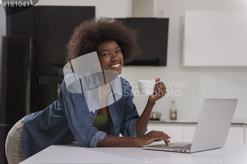 Image of smiling black woman in modern kitchen