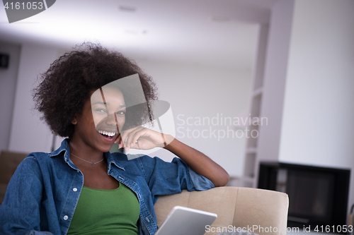 Image of african american woman at home with digital tablet