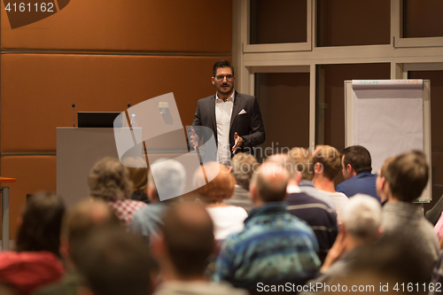 Image of Business speaker giving a talk in conference hall.