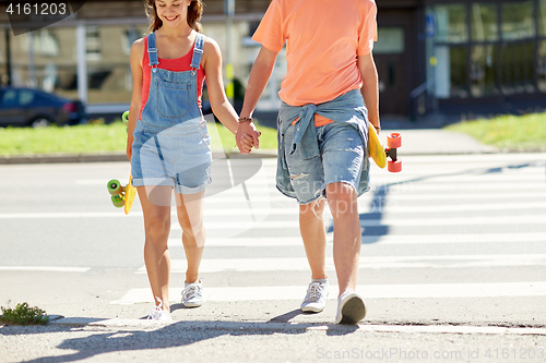 Image of teenage couple with skateboards at city crosswalk