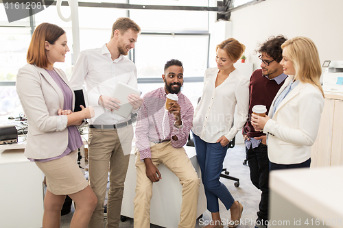 Image of happy business team drinking coffee at office