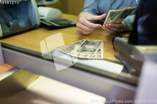 Image of clerk counting cash money at bank office