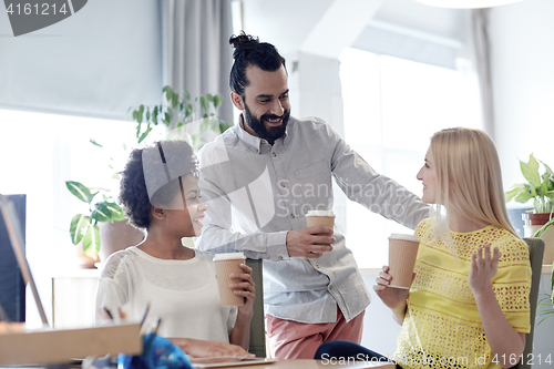 Image of happy creative team drinking coffee in office