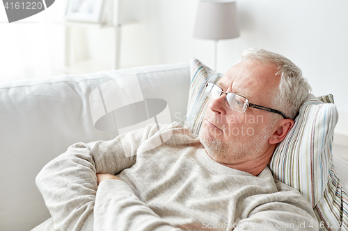 Image of close up of senior man in glasses thinking at home