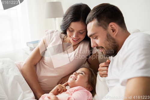 Image of happy family in bed at home