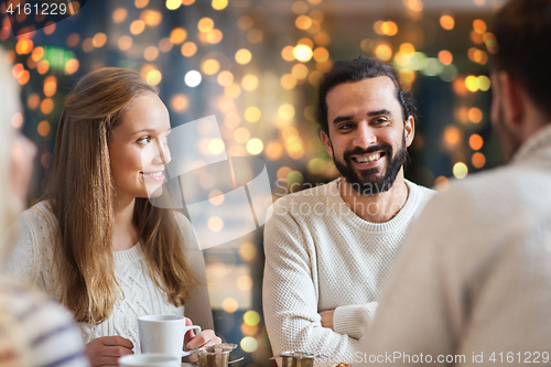 Image of happy friends drinking tea at cafe