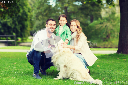 Image of happy family with labrador retriever dog in park