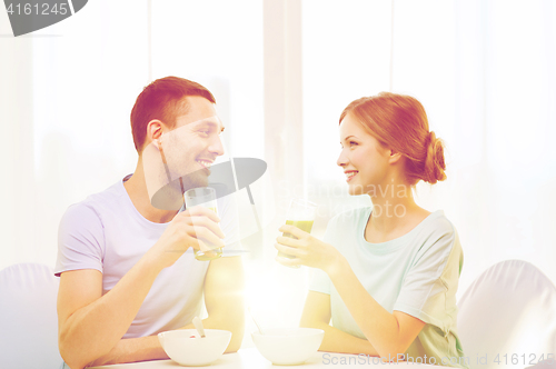 Image of smiling couple having breakfast at home