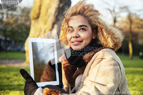 Image of young cute blond african american girl student holding tablet and smiling, lifestyle people concept