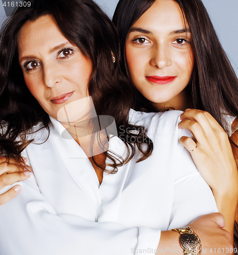 Image of cute pretty teen daughter with mature mother hugging, fashion st