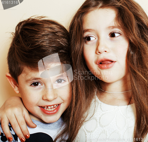 Image of little cute boy and girl hugging playing on white background, ha