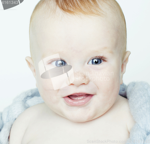 Image of little cute red head baby in scarf all over him close up isolate
