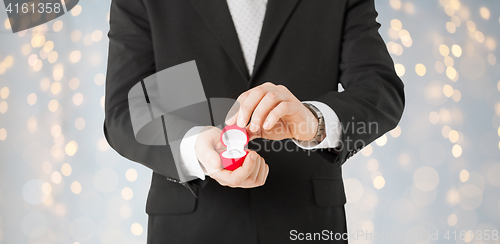 Image of close up of man with engagement ring in gift box