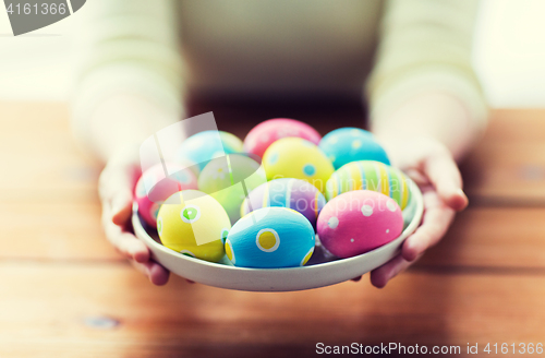 Image of close up of woman hands with colored easter eggs