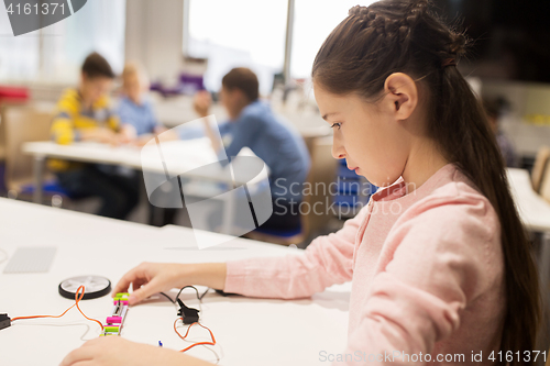 Image of happy girl building robot at robotics school