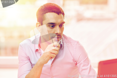 Image of young businessman with laptop computer at office